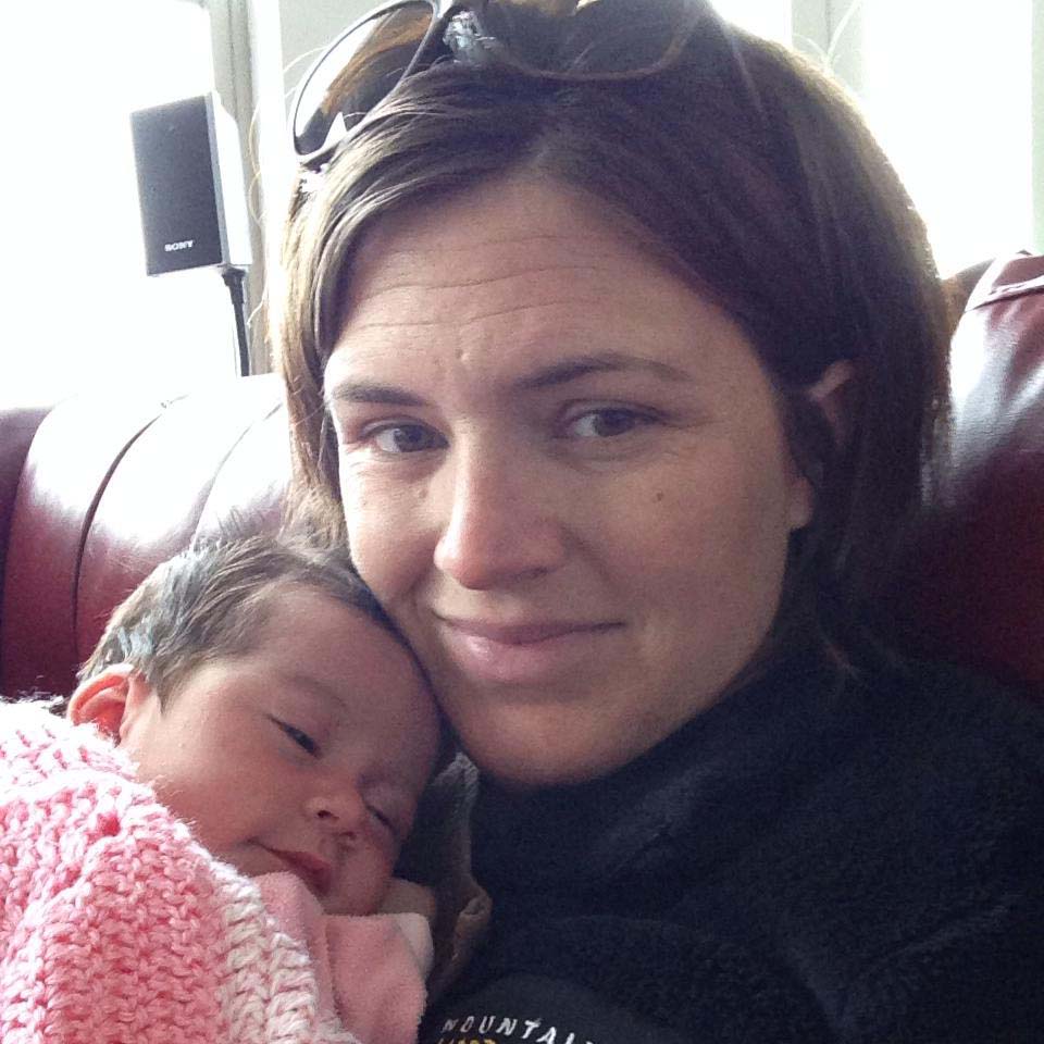 Walker Bravo standing out doors with a pink and red scarf or bandana tied around hair and two yellow flowers over her eyes.