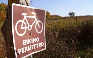 Brown biking permitted sign in outdoor setting