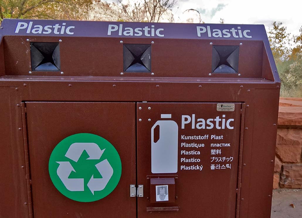 Brown, metal recycling bin with several labeled slots and instructions