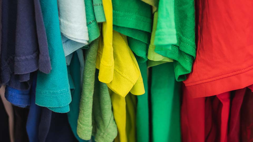 Range of colorful tshirts hanging on a rack