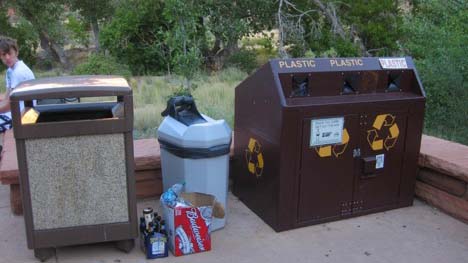 Bottles and boxes in front of recyling and garbage bins
