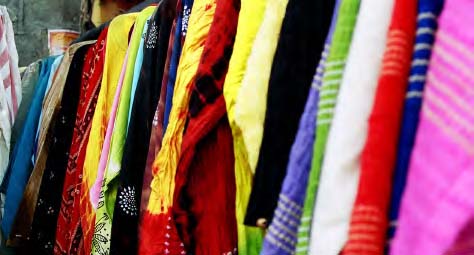 Various types of clothes hanging on racks