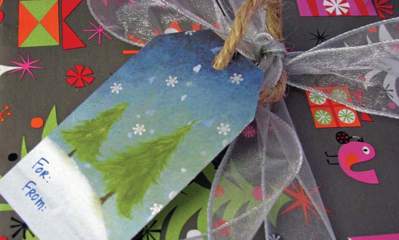 Holiday card with For and From written on it, tied with a bow to gift