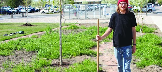 James Wirth Standing in a garden project, holding a shovel or other tool
