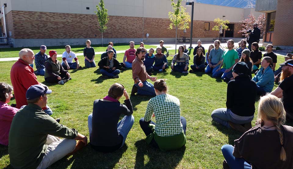 Workshop attendees sitting in a circle on grass