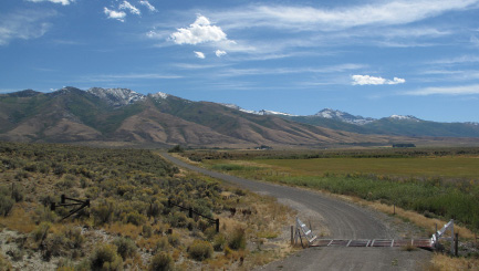 Western landscape with brush and grassland in foreground and mountains in background