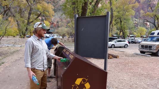 Hikers sorting recycling in outdoor containers