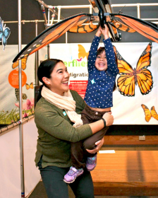 adult and child playing in butterly-themed exhibit maze