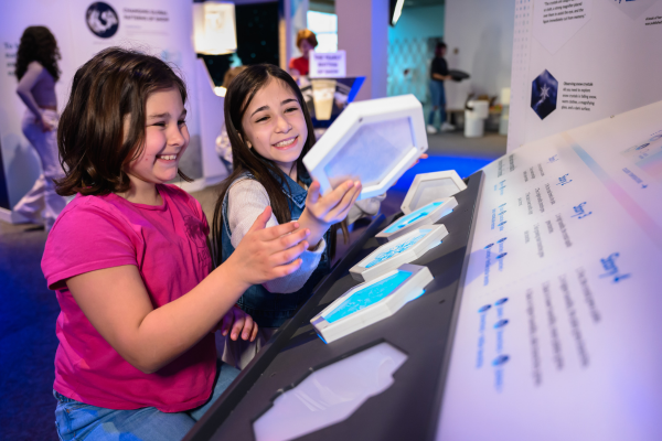 two kids interacting with snow-themed exhibit