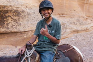 4-H youth riding a mule at Cowboy Camp