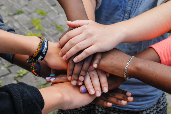 Youth hands in a circle on top of each other about to cheer