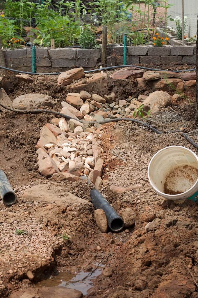 A drain in red rocks under construction.