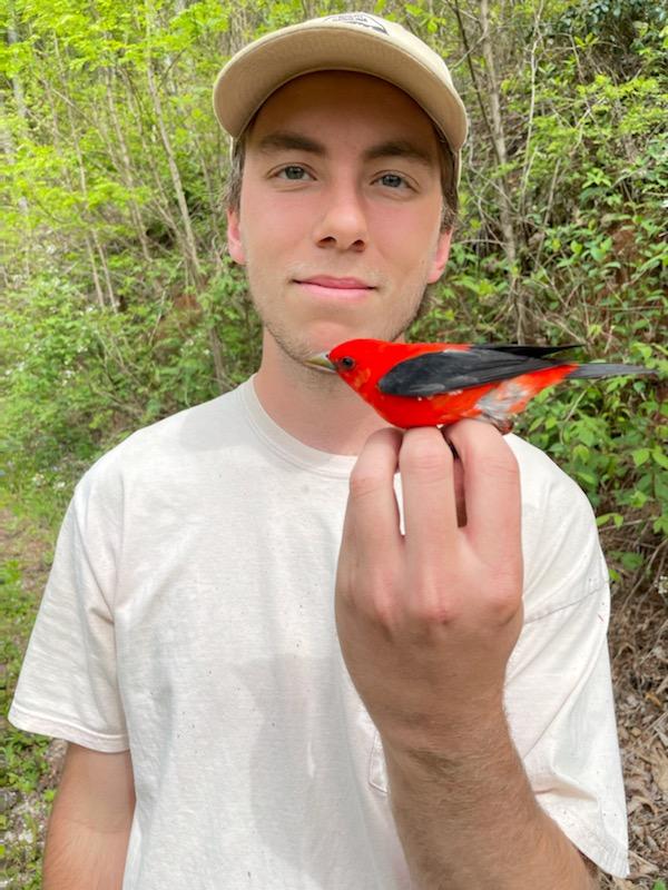 Blake Ledbetter holding a red and black bird