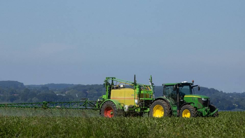 tractor spraying fertilizer on a field