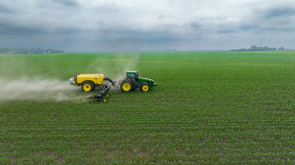 tractor spreading nitrogen on corn field